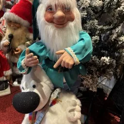 Una marioneta de gnomo montando un lobo blanco, rodeada de decoraciones navideñas.
