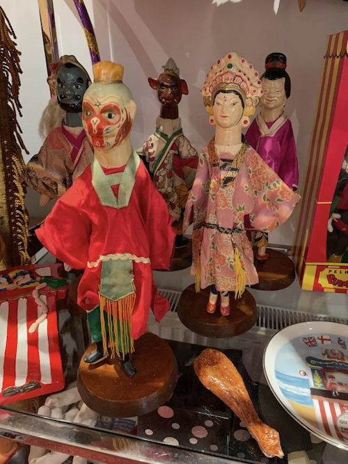 Picture of a display cabinet with many Punch & Judy memorabilia.